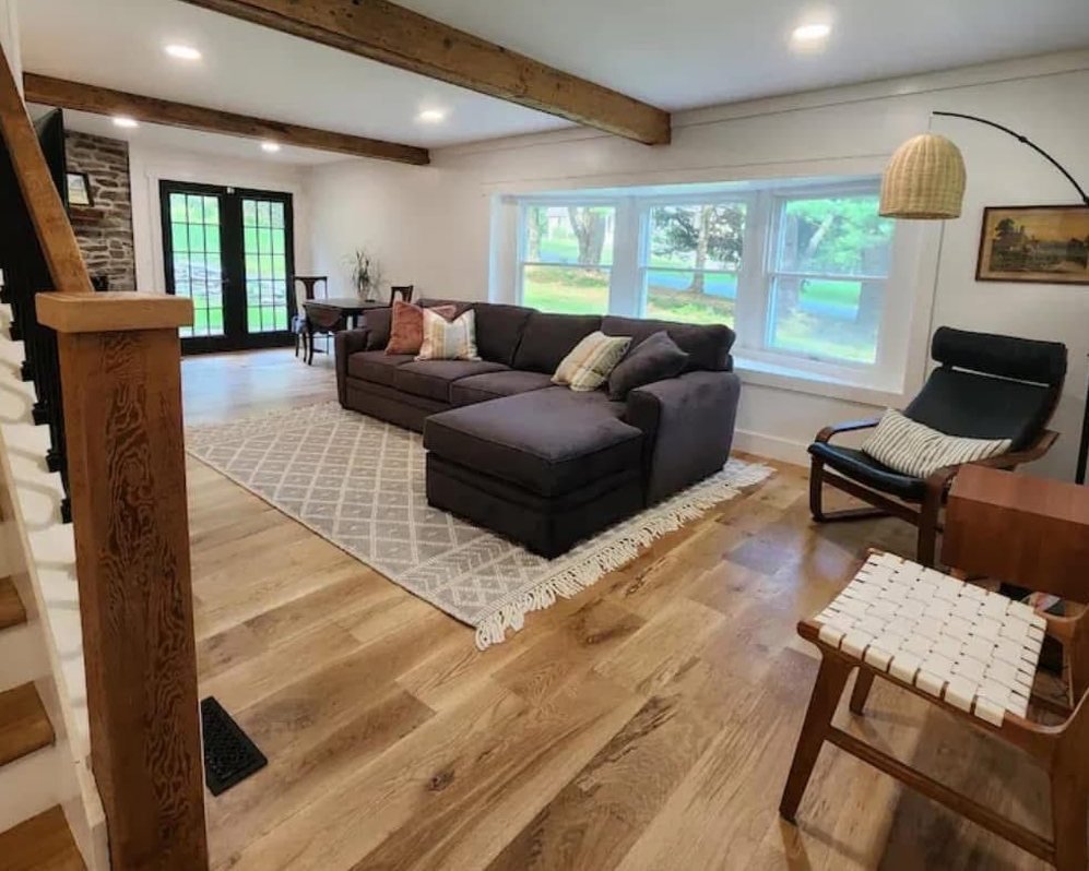 Bright living room with wood floors, exposed beams and a large window