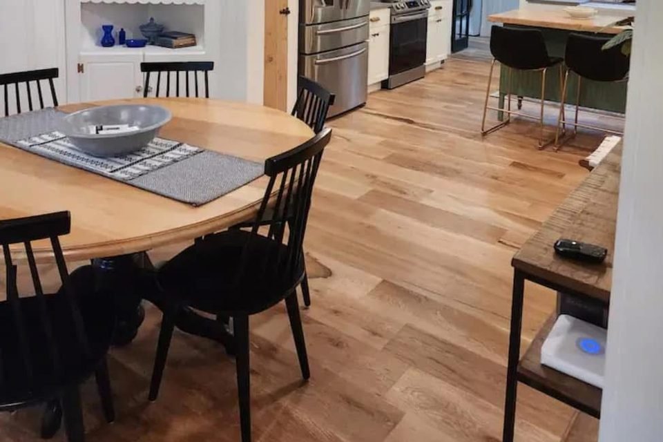 Open dining area and kitchen with clean wood floors